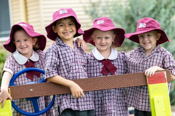 Prep students outside on their wooden car smiling and having fun